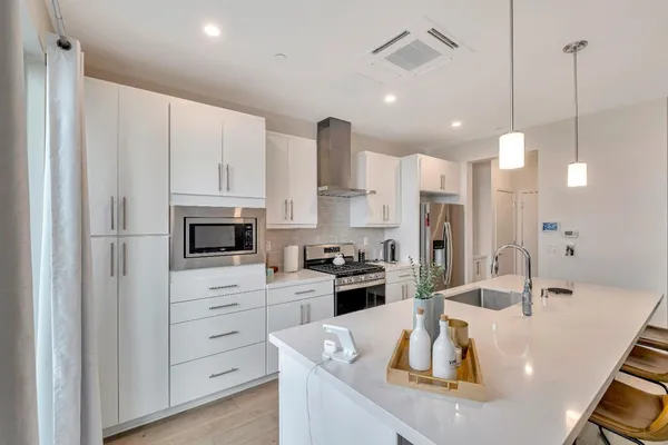 a kitchen with a sink a stove and chairs