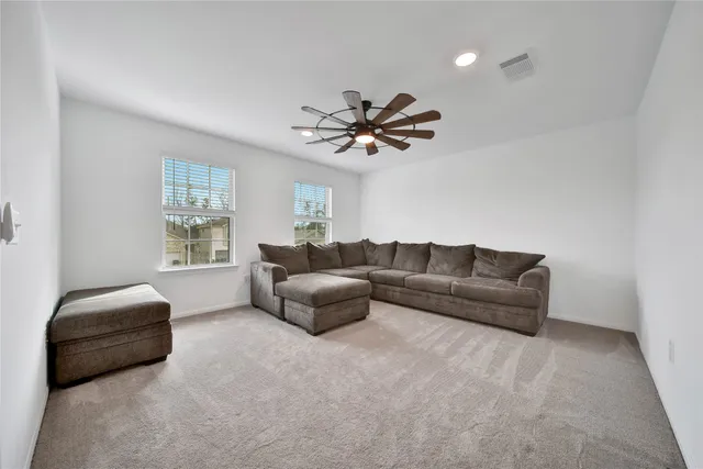 a living room with furniture and a ceiling fan