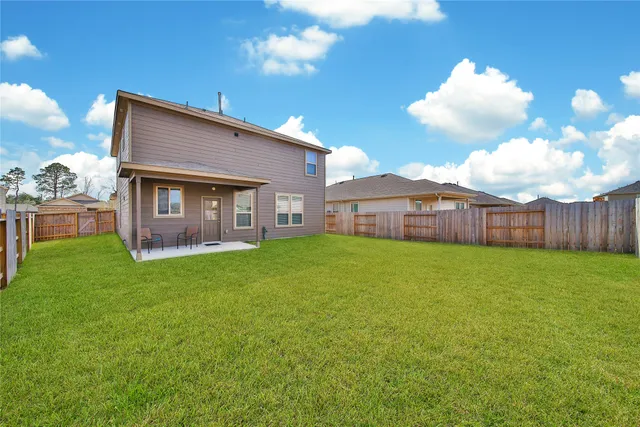 a view of a house with backyard and porch