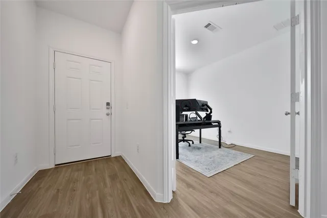 a view of a room with wooden floor and a table