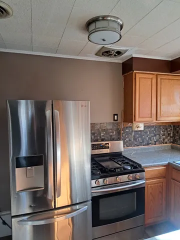 a kitchen with stainless steel appliances granite countertop a refrigerator and a stove