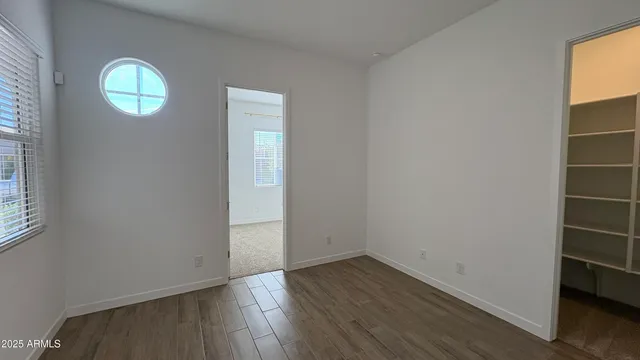 an empty room with wooden floor and window