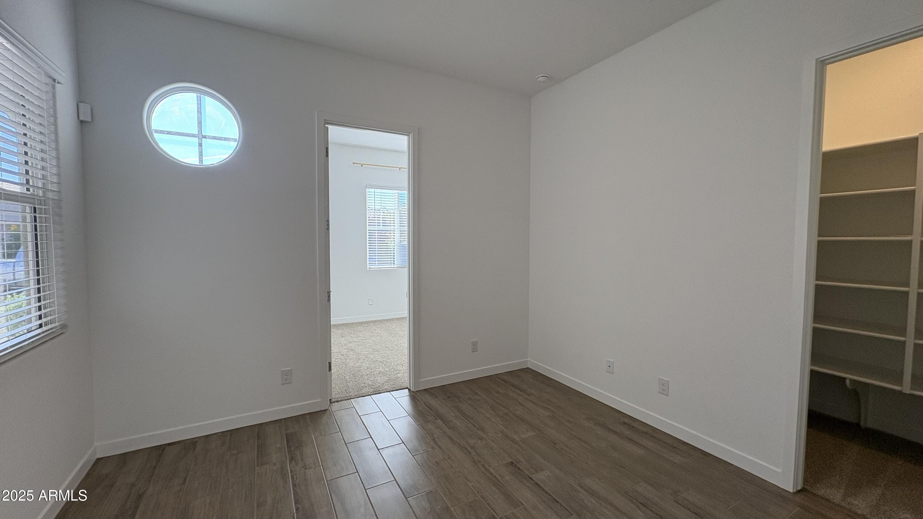 3240 West Peak View Road Phoenix, AZ 85083 - Photo 21 of 37 an empty room with wooden floor and window