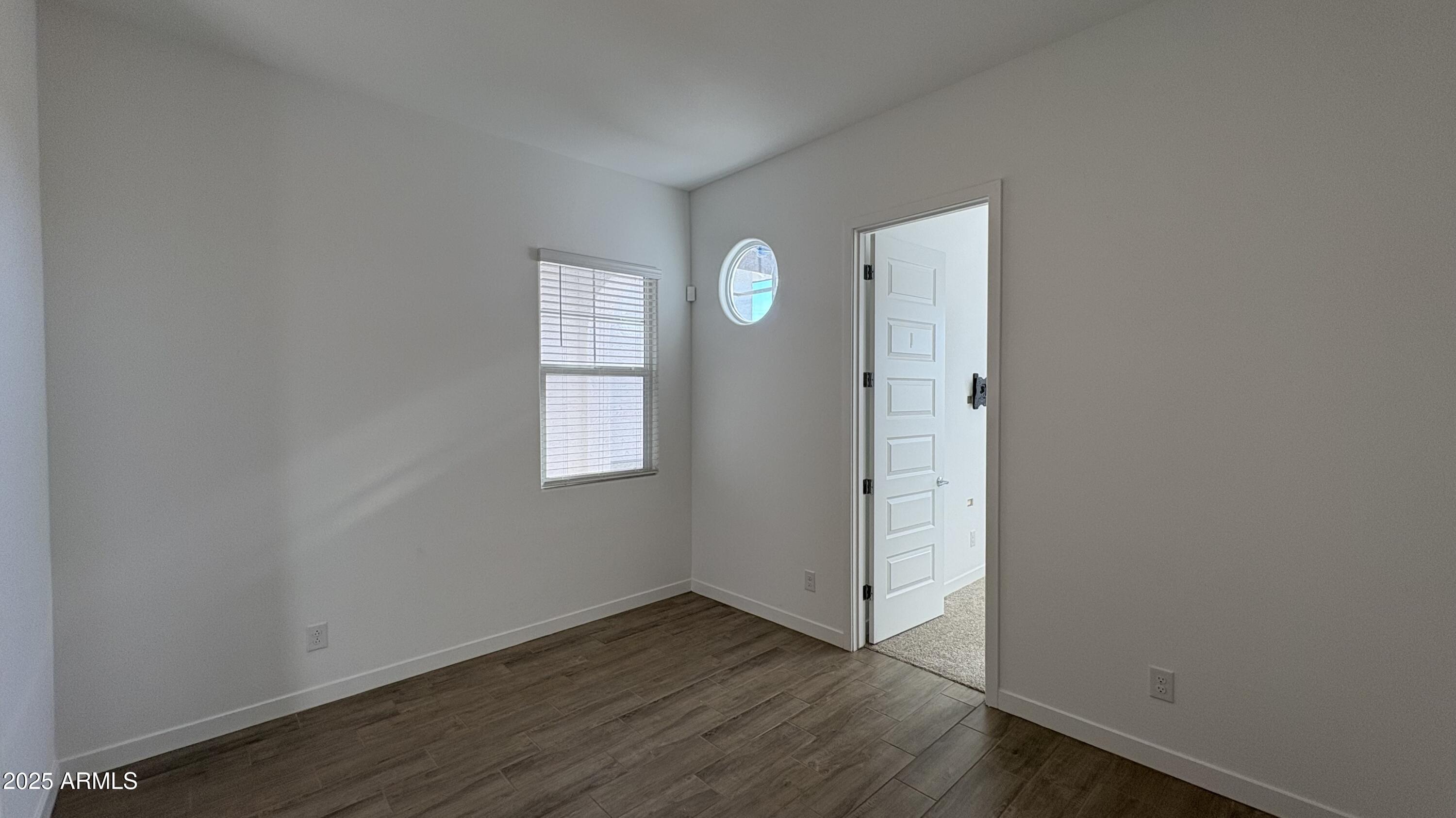 3240 West Peak View Road Phoenix, AZ 85083 - Photo 22 of 37 an empty room with wooden floor and window