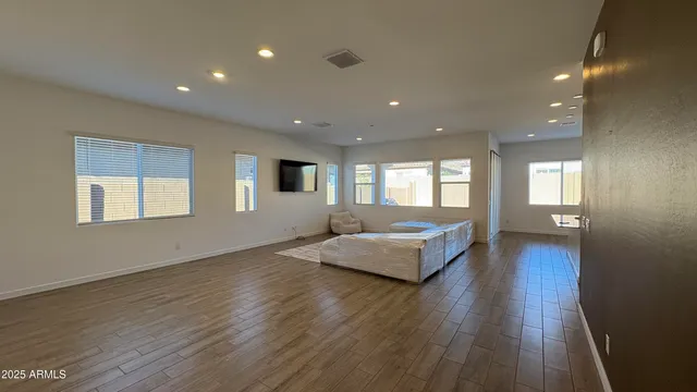 a living room with hard wood floors and a kitchen