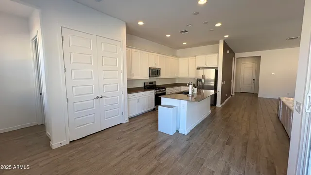 a kitchen with white cabinets and stainless steel appliances