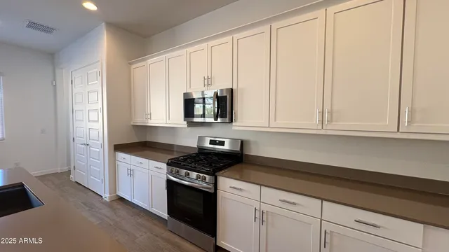 a kitchen with granite countertop white cabinets and black appliances