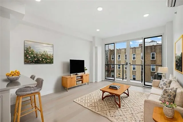 a living room with furniture a rug and a flat screen tv