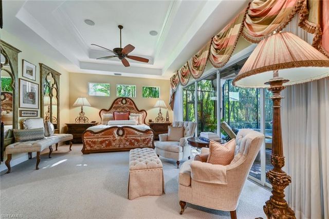 a living room with furniture a chandelier and a large window