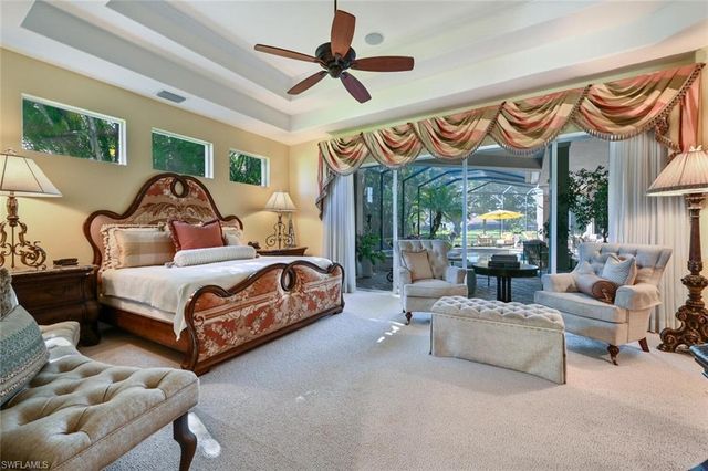 a bedroom with a bed couch and a chandelier