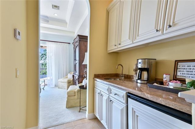 a kitchen with granite countertop a sink stainless steel appliances a counter top space and cabinets