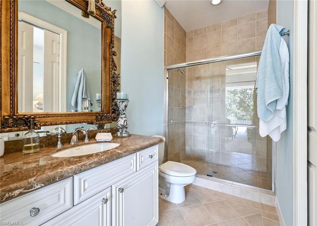 a bathroom with a granite countertop sink toilet and shower