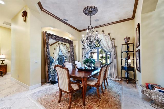 a dining room with furniture a chandelier and window