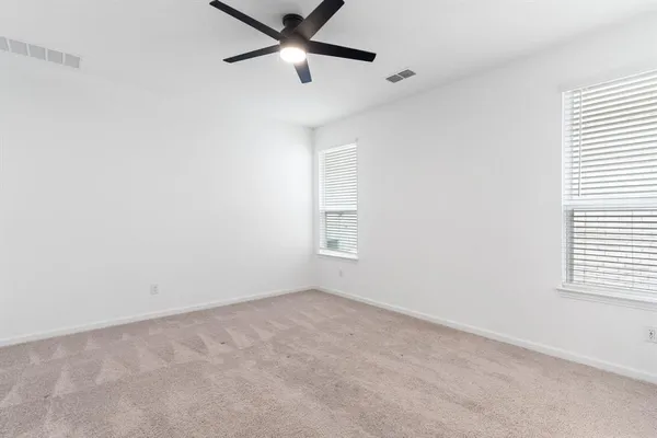 an empty room with a window and a fan