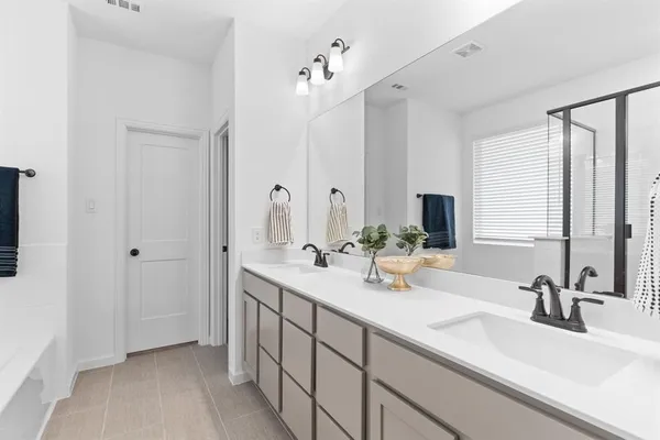 a bathroom with double vanity sink a mirror and shower