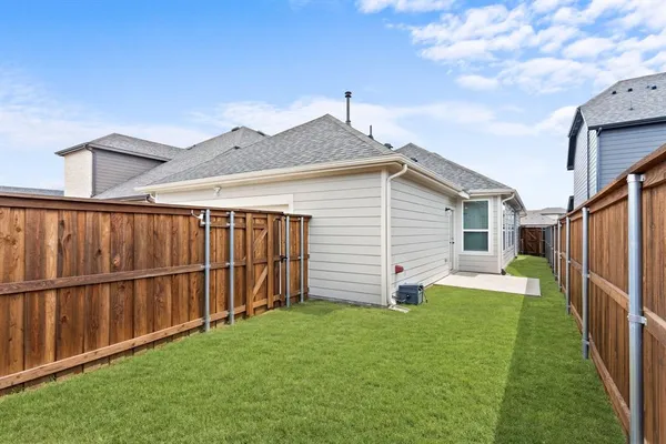 a view of a backyard with wooden fence