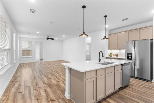 a kitchen with a sink a counter top space stainless steel appliances and cabinets