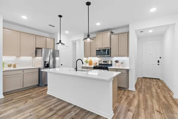 a kitchen with white cabinets sink and stainless steel appliances