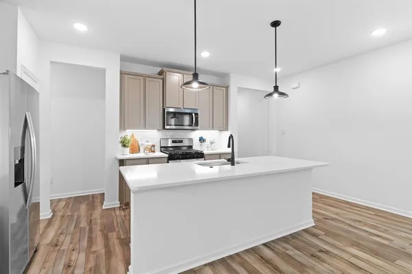 a kitchen with kitchen island a sink appliances and cabinets