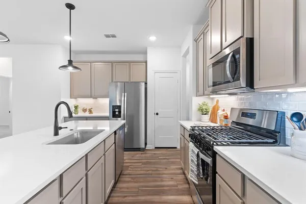 a kitchen with stainless steel appliances granite countertop a sink stove and refrigerator