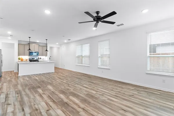 a view of an empty room with kitchen appliances and a window
