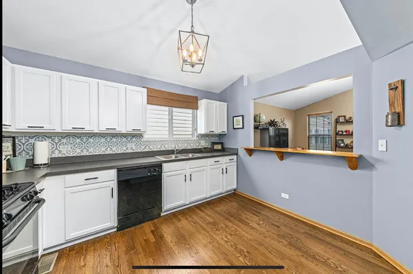a kitchen with granite countertop white cabinets and white appliances