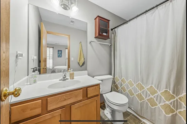 a bathroom with a sink a toilet and shower curtain