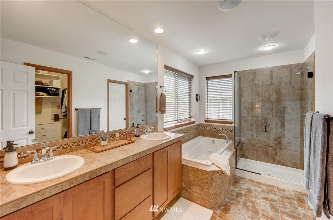22921 42nd Drive Southeast Bothell, WA 98021 - Photo 26 of 38 a bathroom with a granite countertop sink a mirror a bathtub and next to a window