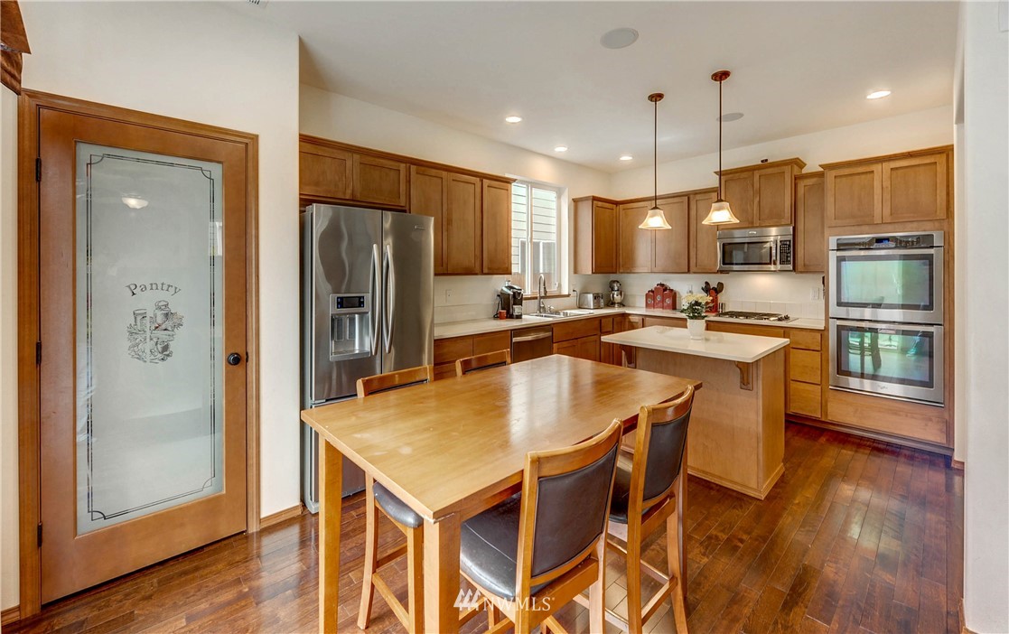 22921 42nd Drive Southeast Bothell, WA 98021 - Photo 4 of 38 a kitchen with stainless steel appliances granite countertop a refrigerator a stove a sink a dining table and chairs with wooden floor