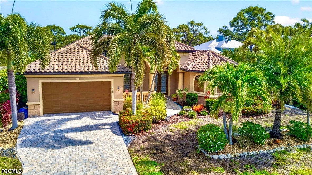 6109 Calusa Rdg Trail Bokeelia, FL 33922 - Photo 2 of 48 a view of a house with brick walls and a tree