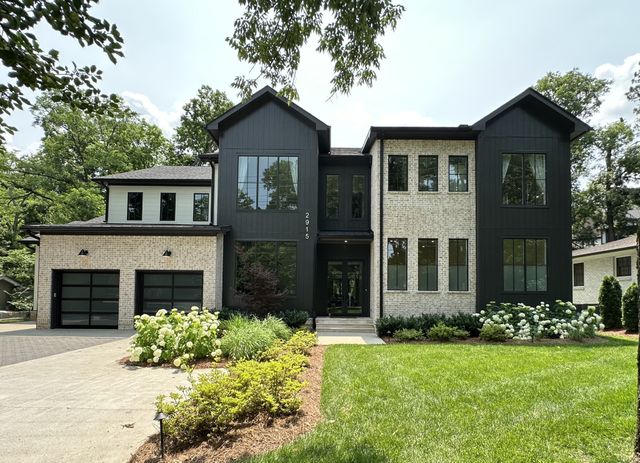 a front view of a house with garden and plants