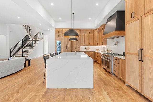 a kitchen with stainless steel appliances granite countertop a refrigerator and a stove top oven