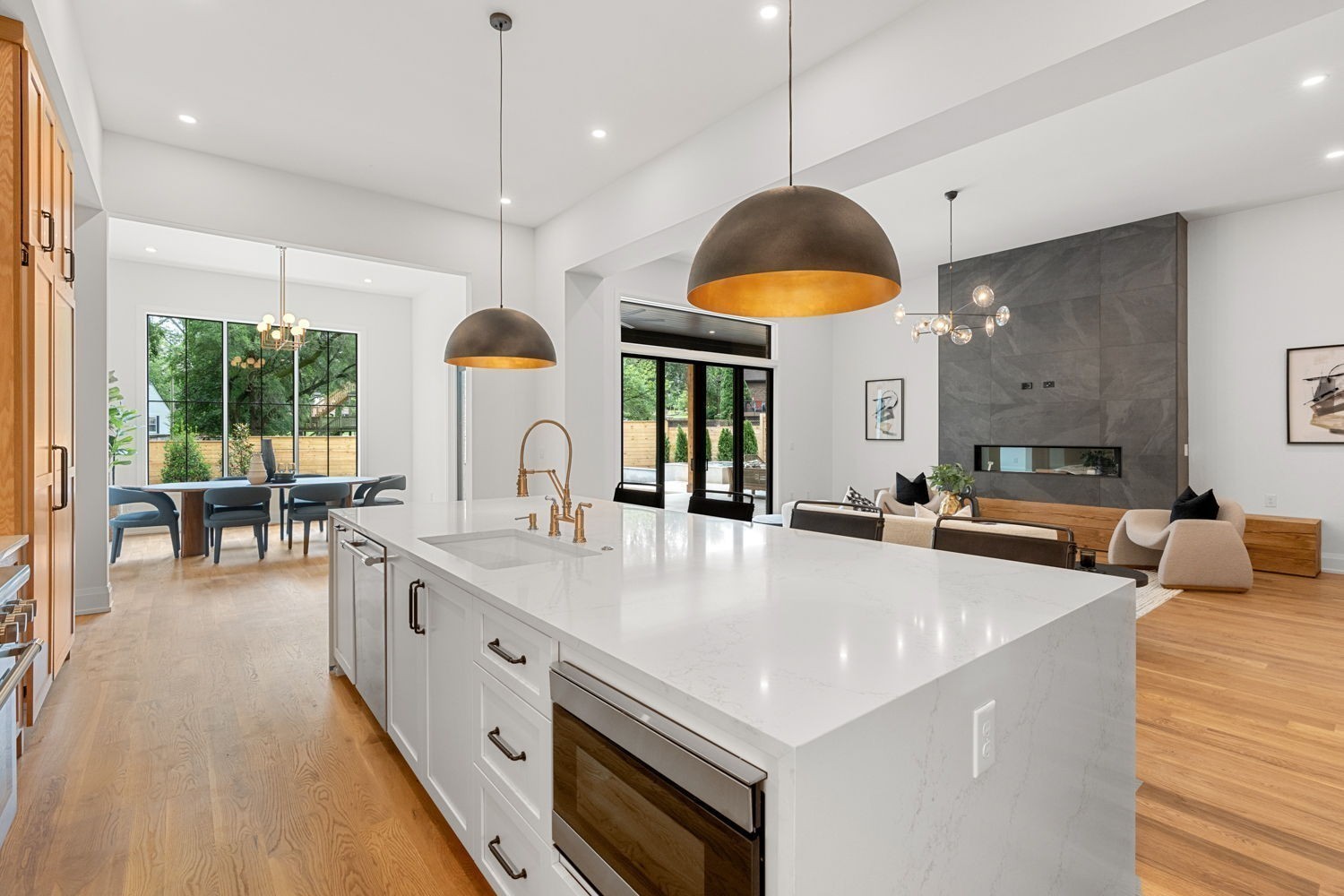 2915 Compton Road Nashville, TN 37215 - Photo 14 of 75 a large white kitchen with a large island oven a sink a stove and a dining table with garden view