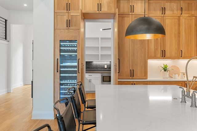 a kitchen with stainless steel appliances a sink and wooden floor