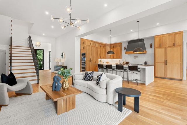 a large kitchen with stainless steel appliances a large center island attached withe living room