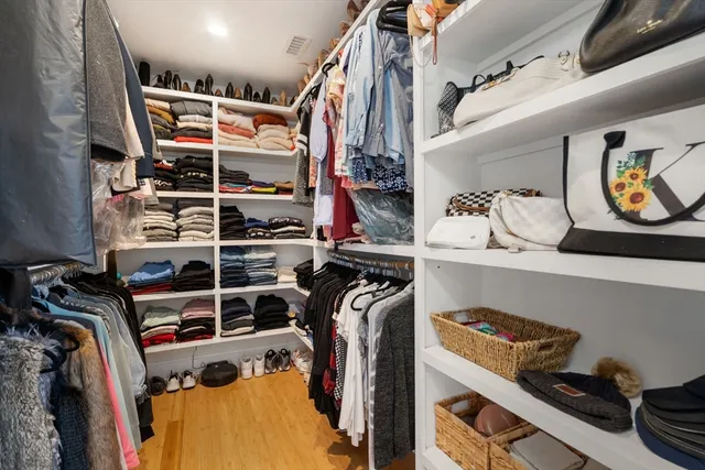 a view of walk in closet with clothes and shoes