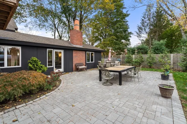 a view of a patio with table and chairs potted plants and a large tree