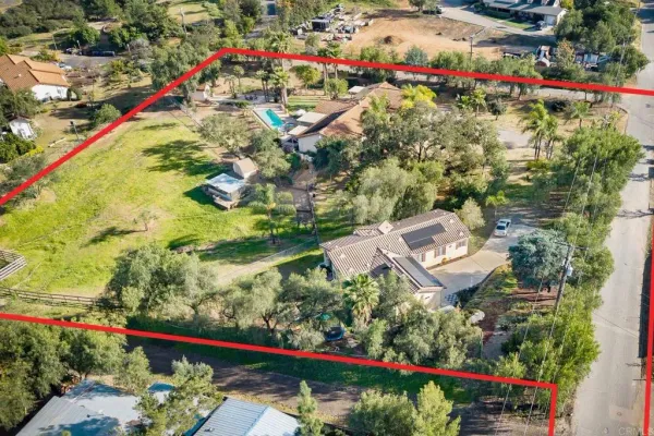 an aerial view of a house with a garden and lake view