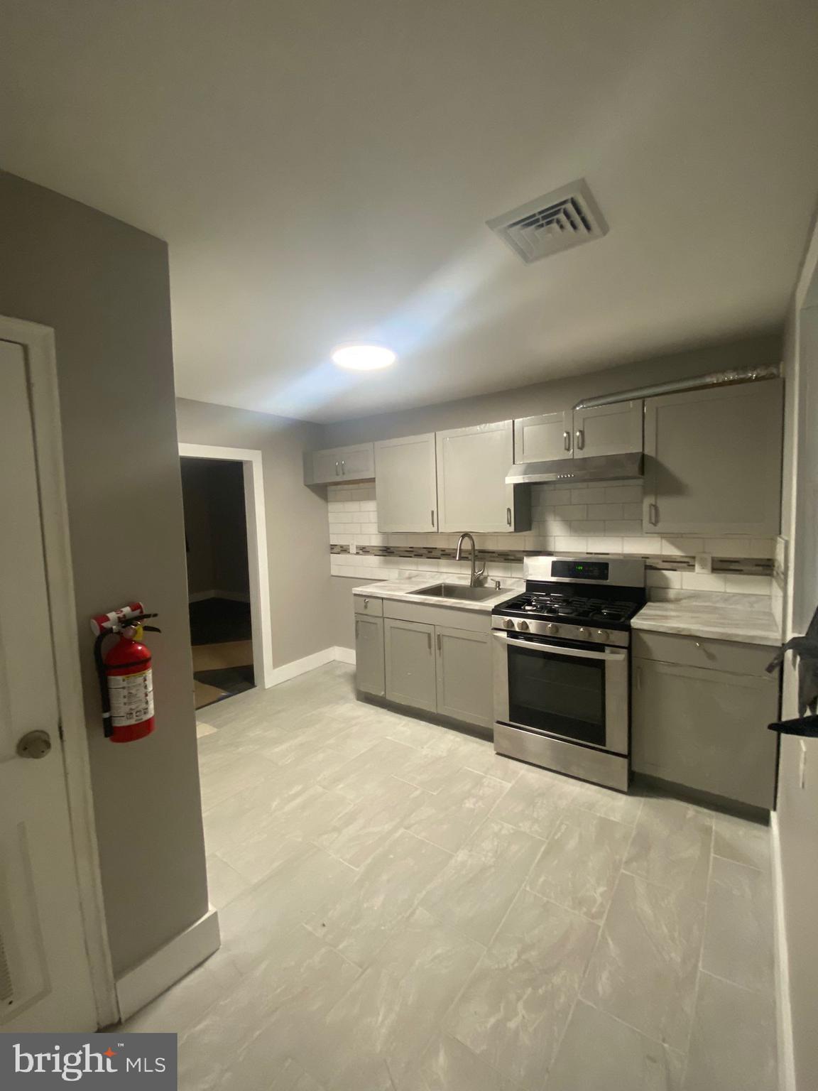 203 Kinsley Road Pemberton, NJ 08068 - Photo 4 of 9 a kitchen with a sink and stainless steel appliances