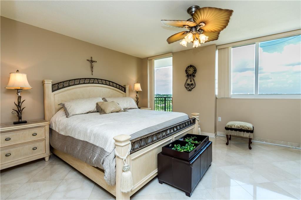 2001 North Ocean Boulevard, Unit 804 Fort Lauderdale, FL 33305 - Photo 11 of 42 a bedroom with a bed and a chandelier