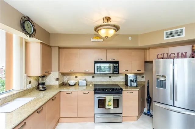 a kitchen with refrigerator a stove a sink and a window