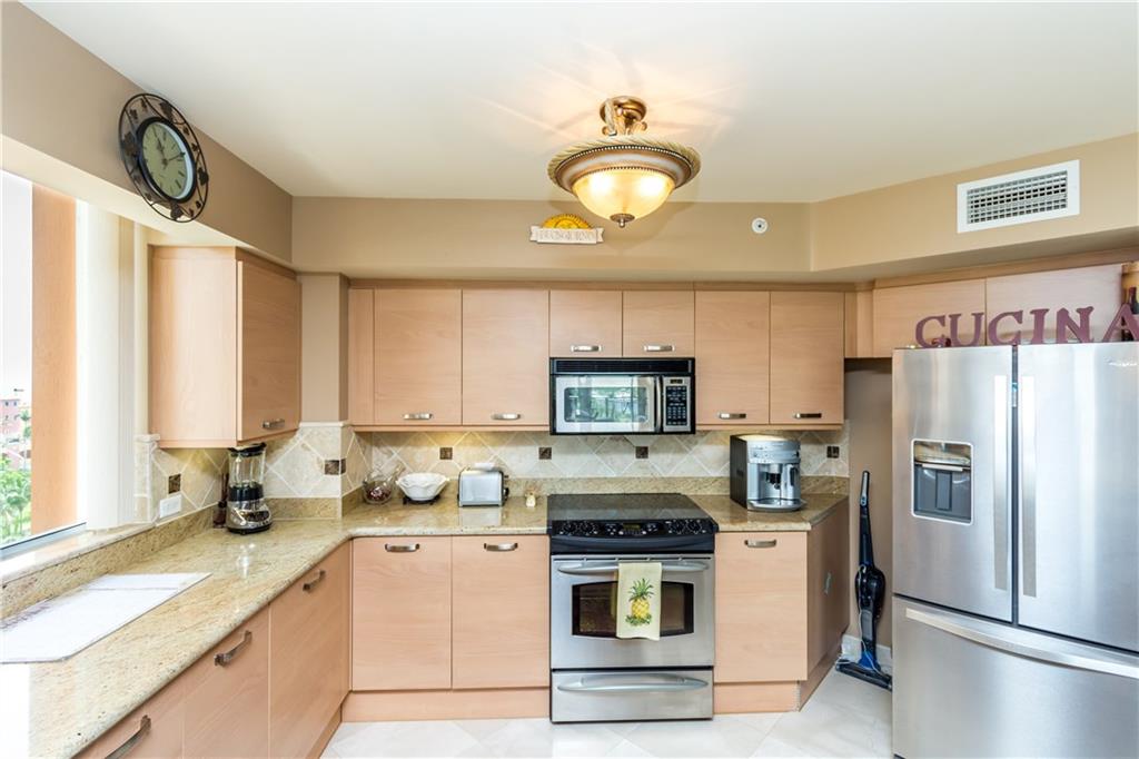 2001 North Ocean Boulevard, Unit 804 Fort Lauderdale, FL 33305 - Photo 4 of 42 a kitchen with refrigerator a stove a sink and a window