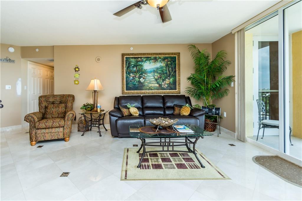 2001 North Ocean Boulevard, Unit 804 Fort Lauderdale, FL 33305 - Photo 8 of 42 a living room with furniture a rug and a chandelier