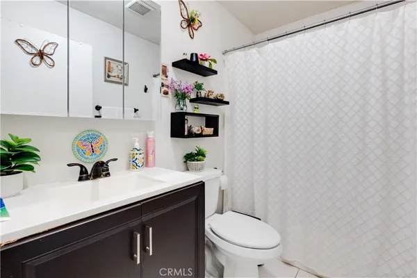 a bathroom with a sink a toilet and a shower curtain