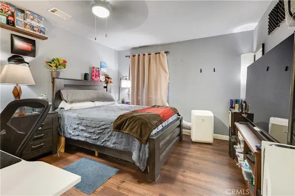 a bedroom with a bed and wooden floor