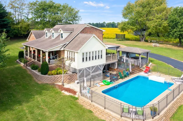 an aerial view of a house with swimming pool and deck