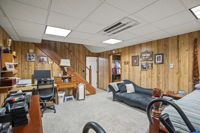 an aerial view of a house with swimming pool and trees in the background