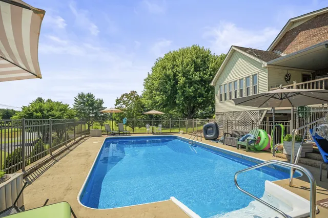 a view of a patio with a table and chairs under an umbrella