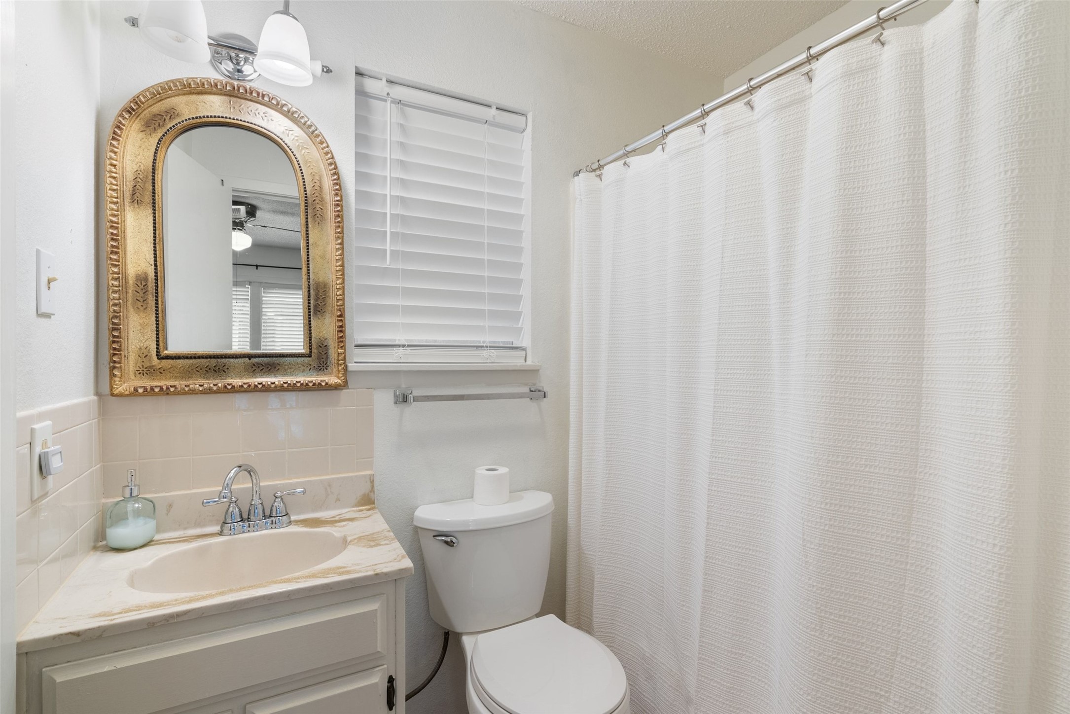 141 Perry Lane Kingsland, TX 78639 - Photo 28 of 40 Brightly illuminated, this bathroom offers a functional vanity with elegant counter space and a clean shower area.