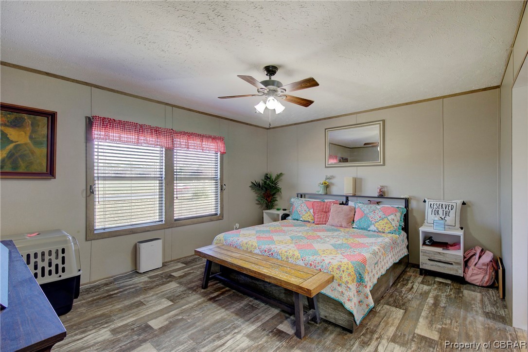 3029 Carsley Road Dendron, VA 23839 - Photo 6 of 26 Bedroom with hardwood / wood-style flooring, a textured ceiling, and ceiling fan